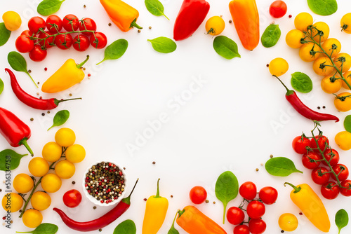 Yellow and red tomatoes  hot peppers spinach and spices on a white background  food background  top view  copy space