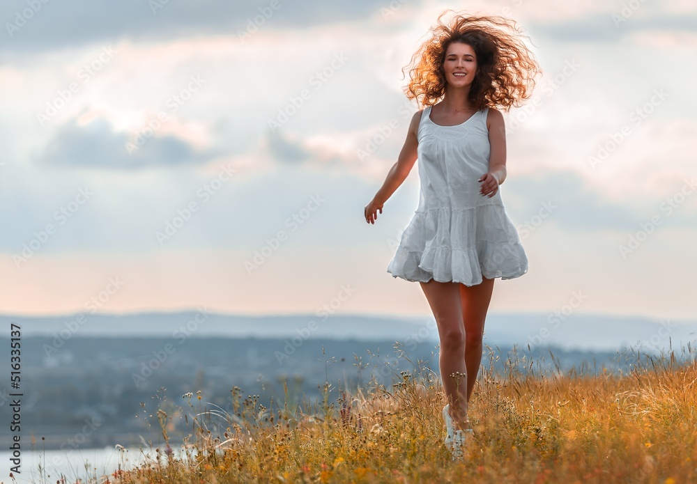 Woman run and relax in the field with flowers on sunset background Woman run and relax in the field with flowers on sunset background