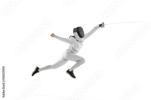 Dynamic portrait of female fencer in sports costume with rapier in hand training isolated on white background. Sport, youth, healthy lifestyle, achievements.