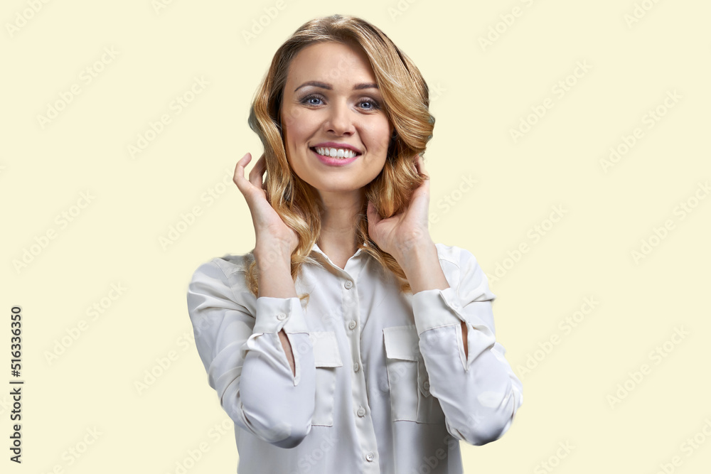 Pretty smiling blonde woman touching her hair and looking at camera. Isolated on white background. Pretty smiling blonde woman touching her hair and looking at camera. Isolated on white background.
