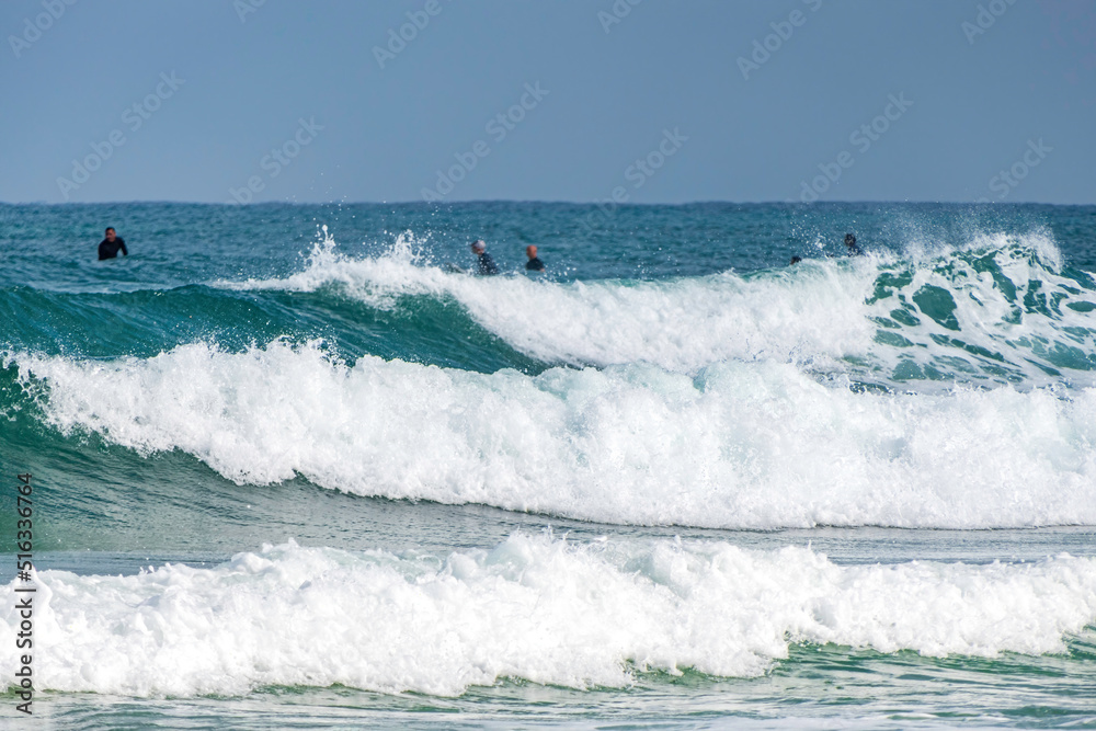 Surfers in the water on the waves of the Mediterranean Sea.