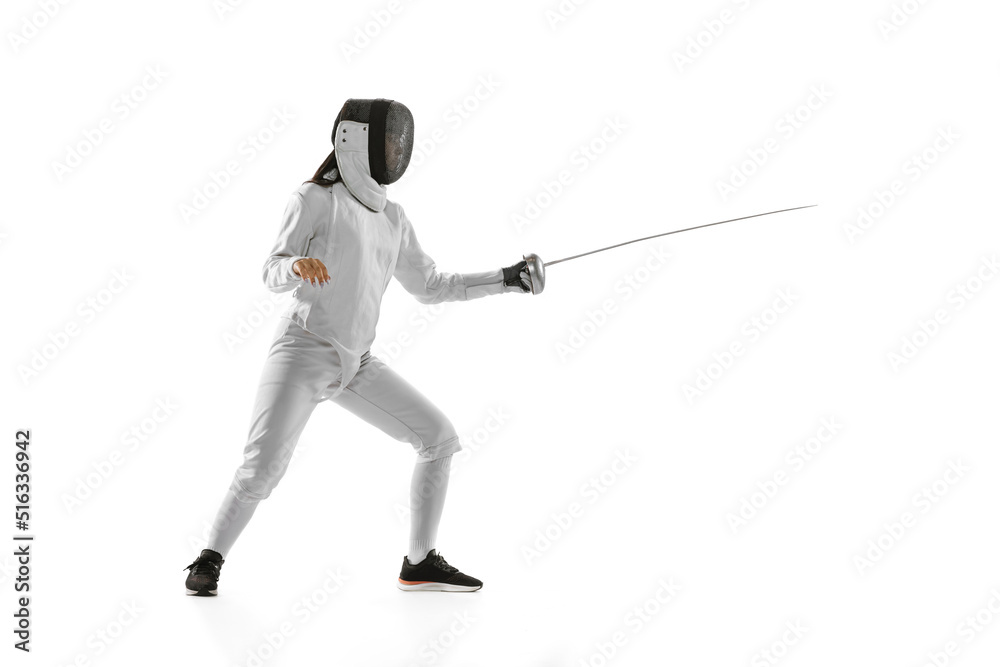 Dynamic portrait of female fencer in sports costume with rapier in hand training isolated on white background. Sport, youth, healthy lifestyle, achievements.