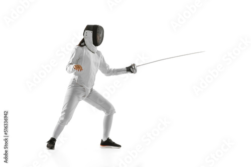 Dynamic portrait of female fencer in sports costume with rapier in hand training isolated on white background. Sport, youth, healthy lifestyle, achievements. photo