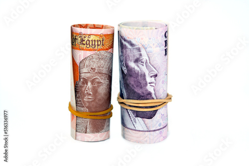 Egypt money roll of new first Egyptian 10 LE EGP ten pounds plastic polymer banknote and the old paper note isolated on white background, Egyptian pounds cash money bills rolled up with rubber bands photo