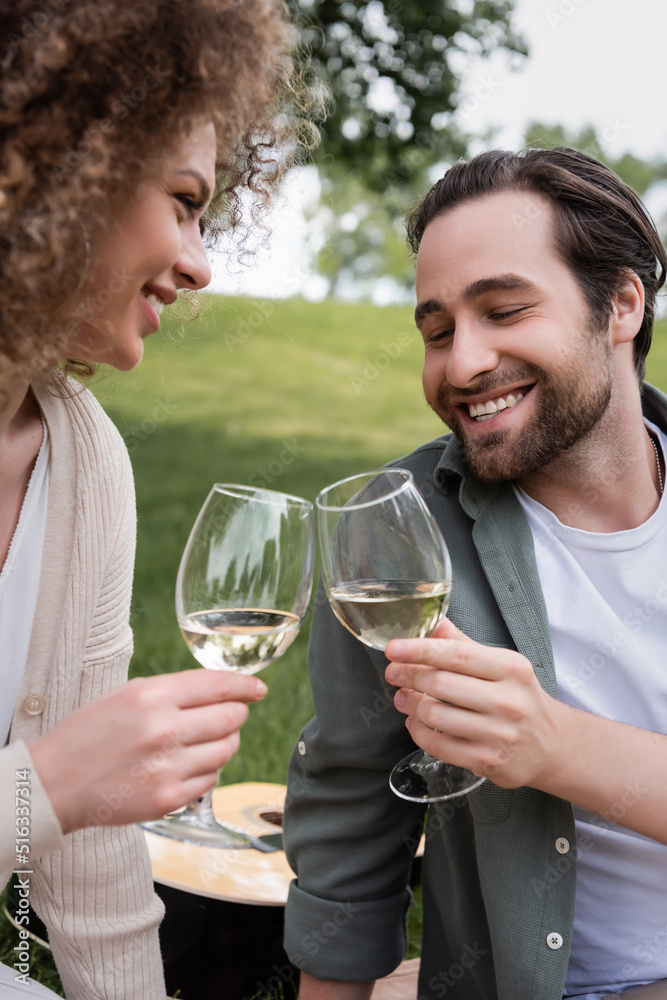 happy young couple clinking glasses of wine during picnic. happy young couple clinking glasses of wine during picnic.