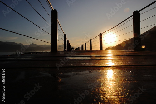 Wooded bridge in the port during sunrise.