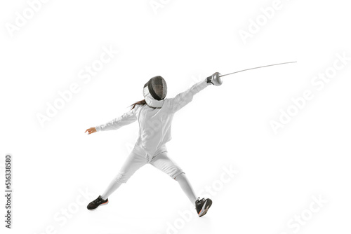Dynamic portrait of female fencer in sports costume with rapier in hand training isolated on white background. Sport, youth, healthy lifestyle, achievements. © master1305