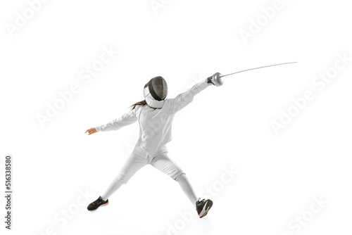 Dynamic portrait of female fencer in sports costume with rapier in hand training isolated on white background. Sport, youth, healthy lifestyle, achievements.