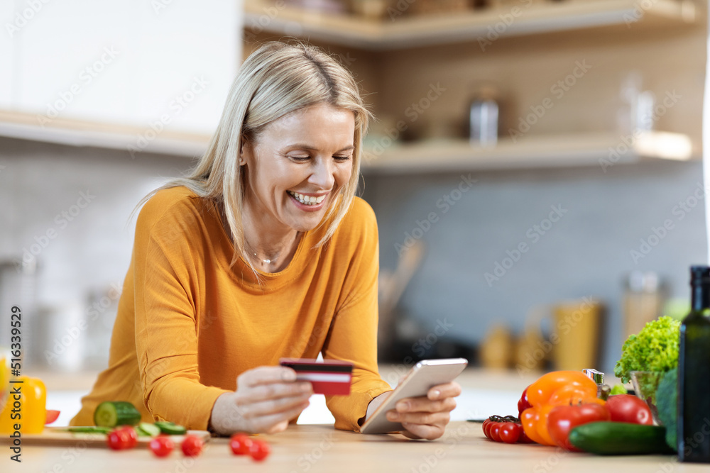 Happy blonde woman buying food online, using smartphone Happy blonde woman buying food online, using smartphone