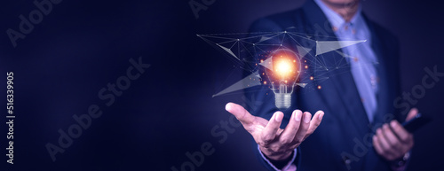 Businessman hand holding light bulb with finance document and tool,concept of New ideas for business and fonance. photo