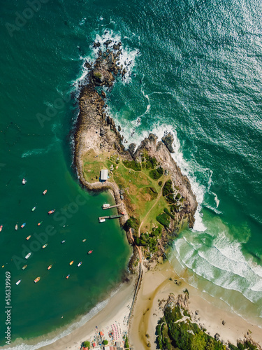 Aerial view of coastline with rocky island, beach and ocean with boats in Brazil. Matadeiro Beach and Ponta das Campanhas