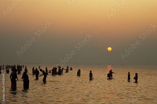Hindu pilgrims bathing at dawn at Ganga Sagar Mela yearly pilgrimage at the mouth of the Ganges