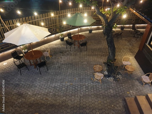Top view of the restaurant garden with tables, chairs and hanging lights photo