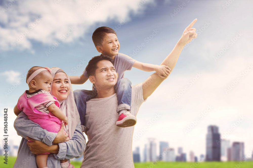 Muslim family look at something near modern city Muslim family look at something near modern city