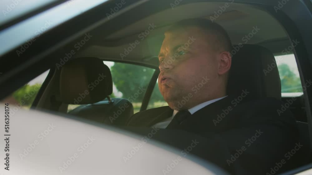 Furious angry man standing in a traffic jam beeps and hurries. Sitting in the car.Stressful commuting to be late work.Close up Furious angry man standing in a traffic jam beeps and hurries. Sitting in the car.Stressful commuting to be late work.Close up