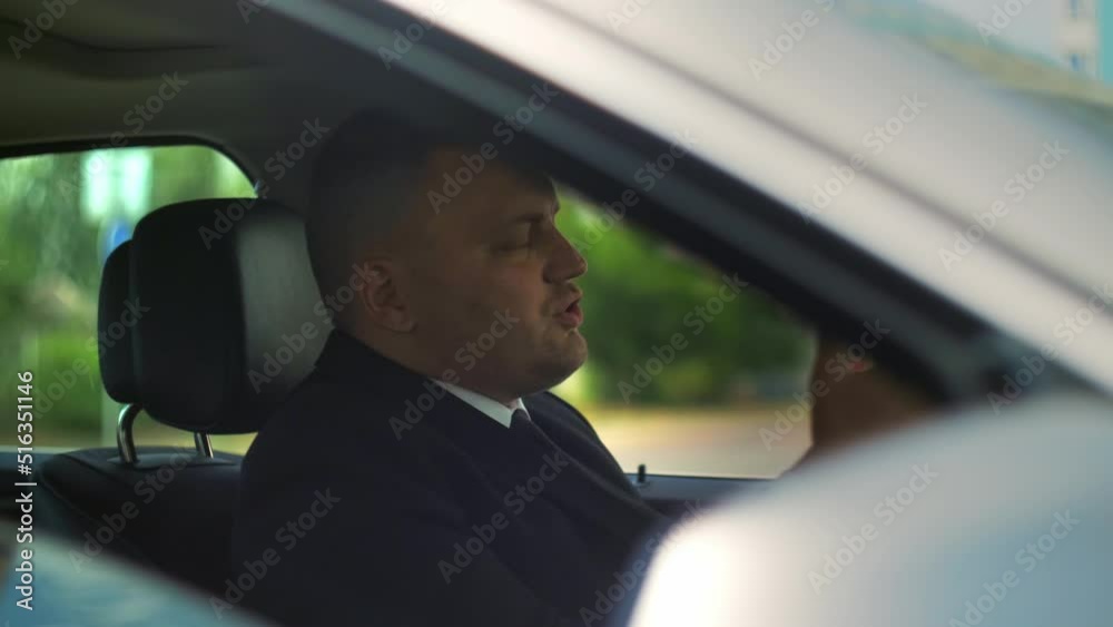 Unhappy young man driving sitting car in traffic city at sunlight. Feel angry stress depression. Look serious automobile. Frustrated tired. Close up.Slow motion Unhappy young man driving sitting car in traffic city at sunlight. Feel angry stress depression. Look serious automobile. Frustrated tired. Close up.Slow motion