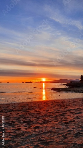 Vertical breathtaking view of a colorful sunset from the beach photo