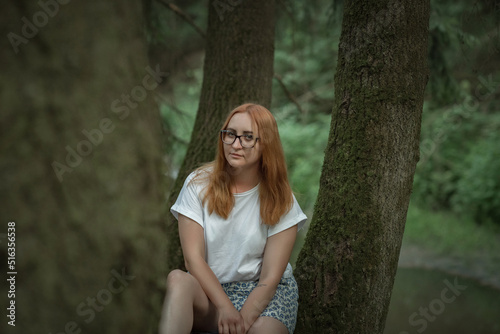 Portrait of a young beautiful girl in glasses in the forest.