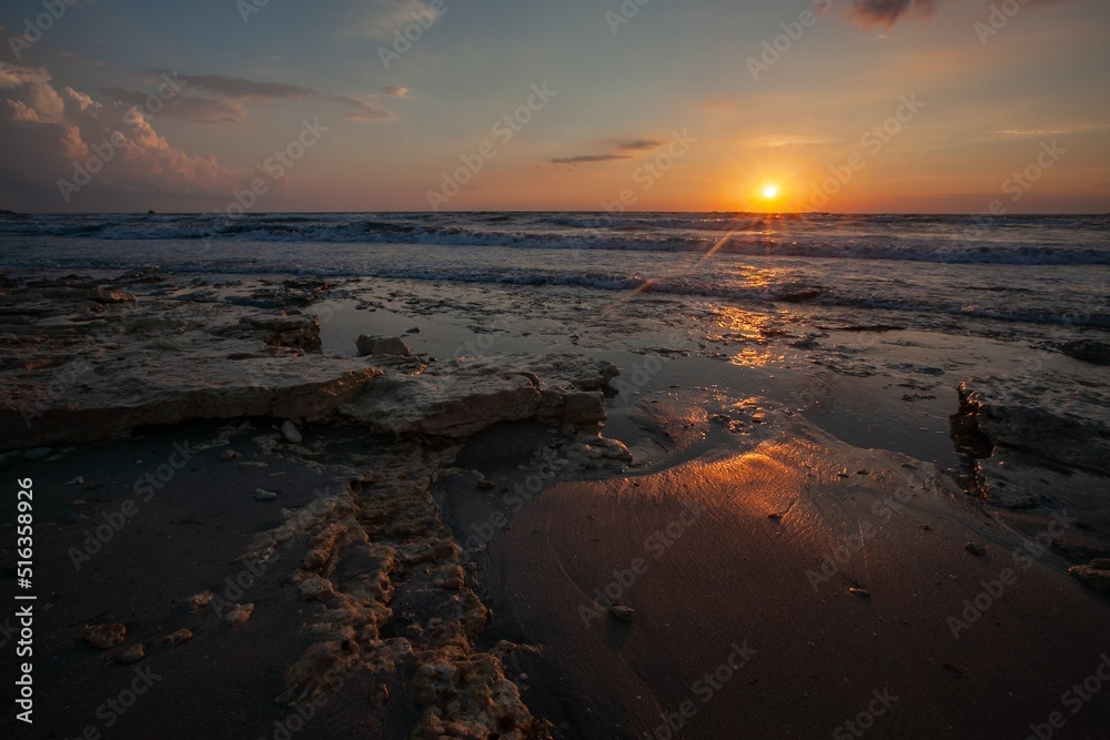 Evening orange sky with dramatic clouds and sea