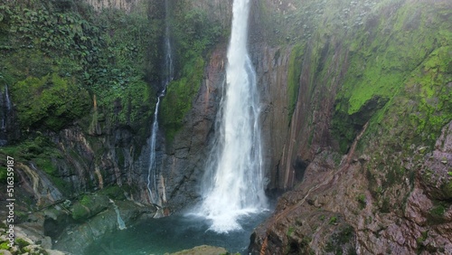 Waterfall surrounded by rocks covered with green vegetation. Catarata del Toro, Costa Rica. photo