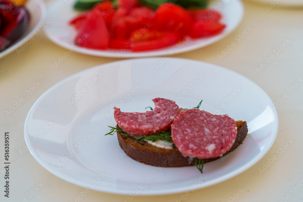 Sandwich with smoked sausage on a white plate