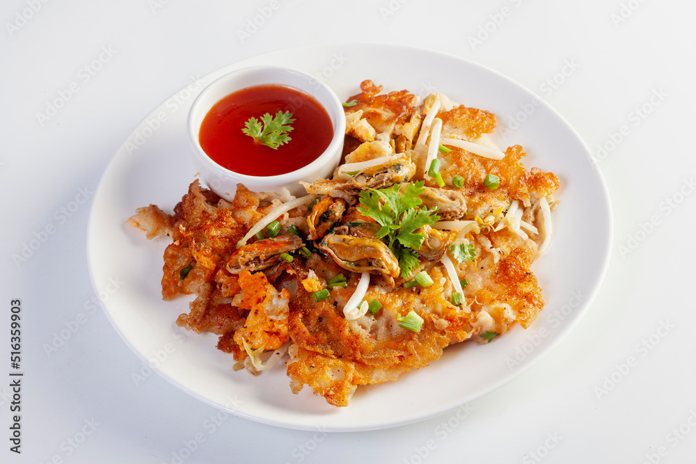 Crispy fried mussels omelette served with bean sprout and spicy sauce. Crispy fried mussels omelette served with bean sprout and spicy sauce.