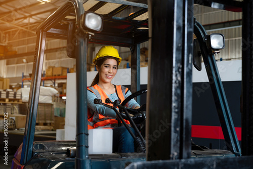 Portrait of woman forklift driver in factory, Woman cargo worker work in warehouse.