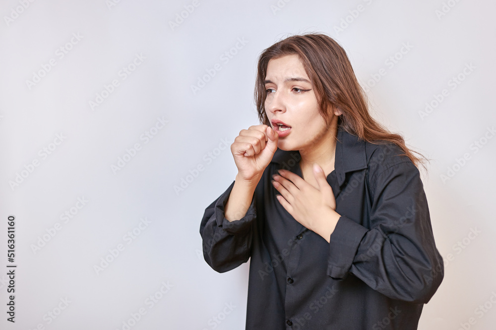 A girl in a black shirt coughs uncontrollably. Cough and cold concept. A girl in a black shirt coughs uncontrollably. Cough and cold concept.