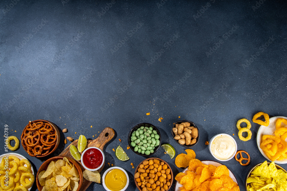 Various Unhealthy Salty Bar Snacks Set Dark Grey Table Background With various-unhealthy-salty-bar-snacks-set-dark-grey-table-background-with