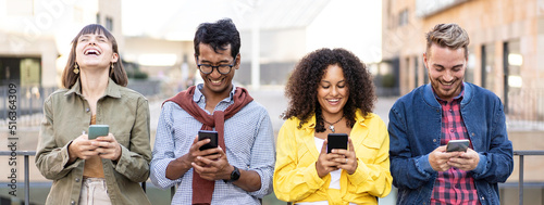 Horizontal banner or header with multiracial friends laughing using smartphone in the university district of the city - Young people addicted by mobile smart phones