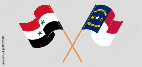 Crossed and waving flags of Syria and The State of North Carolina