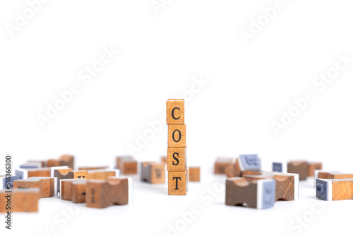Stamp Wooden cubes form the word cost spelled letters. Concept of production cost management, cost cut in business, optimize continuous improvement.