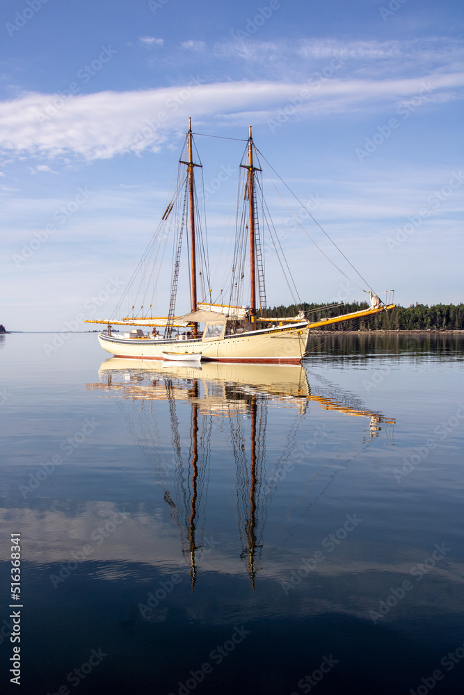 a schooner and its reflection in water