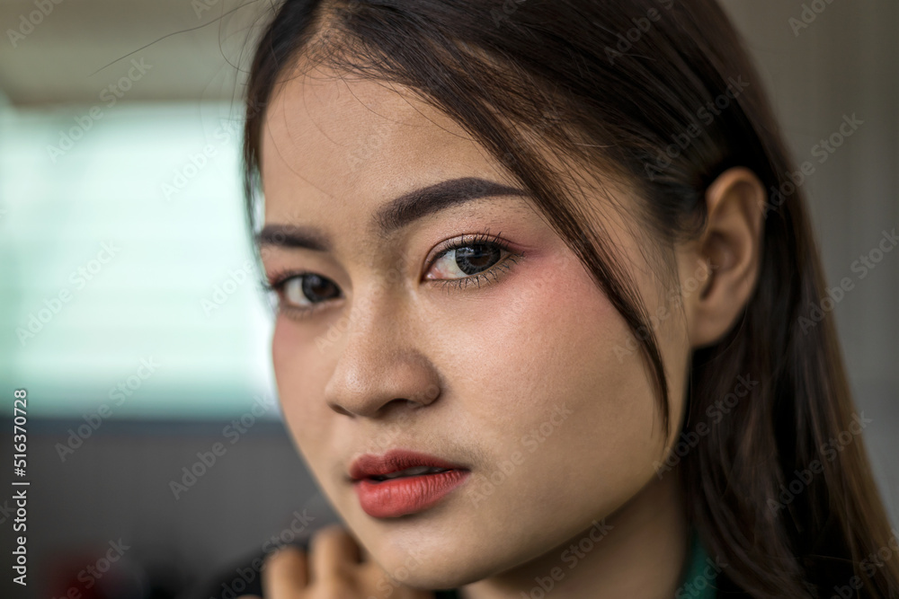 A close-up of a portrait of a beautiful Thai woman smiling seductively inside her coffee shop. A close-up of a portrait of a beautiful Thai woman smiling seductively inside her coffee shop.