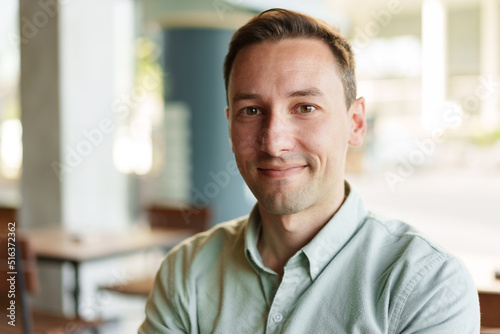 Confident young businessman sitting at cafe portrait