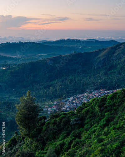 Morning sunrise view of the hills in Ooty with blue tinted landscape and Orange sky