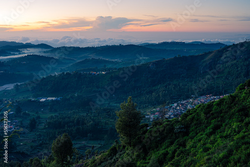 Morning sunrise view of the hills in Ooty with blue tinted landscape and Orange sky