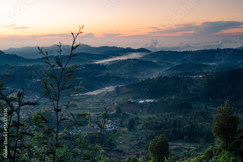 Morning sunrise view of the hills in Ooty with blue tinted landscape and Orange sky