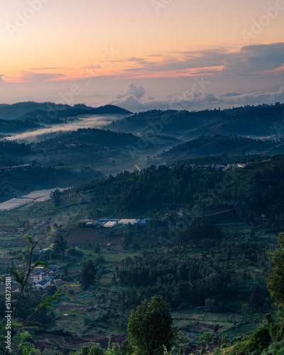 Morning sunrise view of the hills in Ooty with blue tinted landscape and Orange sky