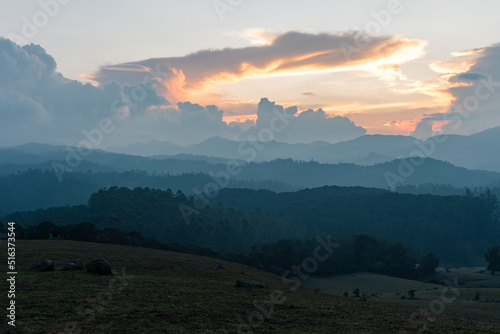 Morning sunrise view of the hills in Ooty with blue tinted landscape and Orange sky