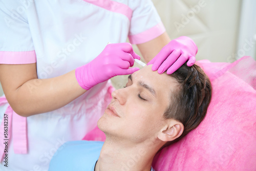 Young man doing antiage injections in salon