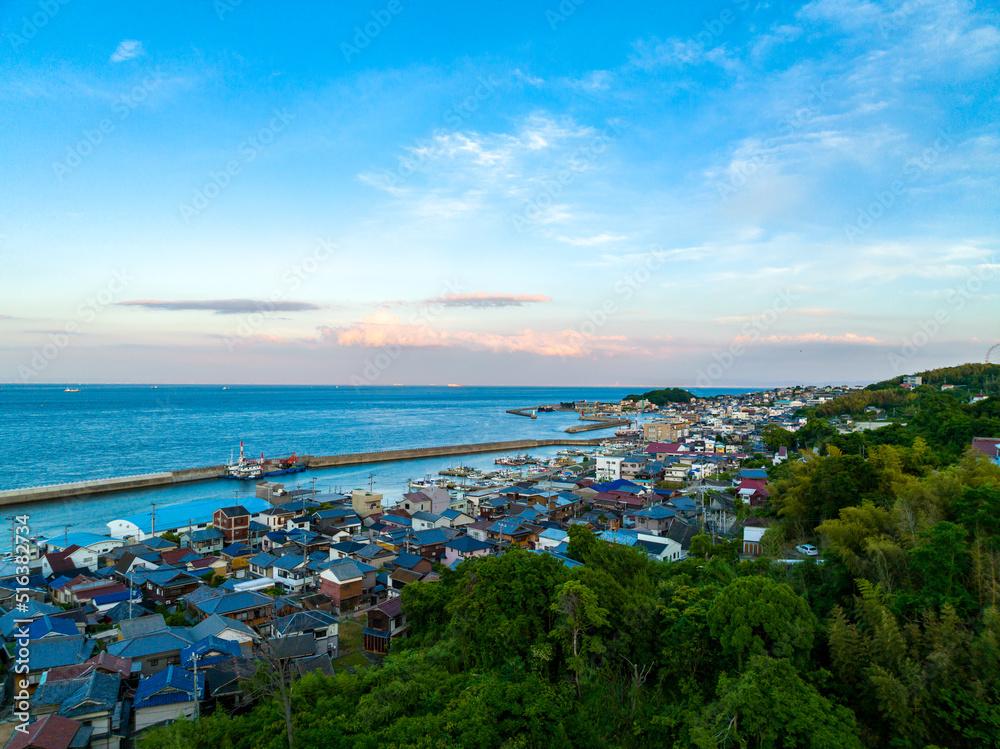 Aerial view of small Japanese fishing town with sunset clouds in background