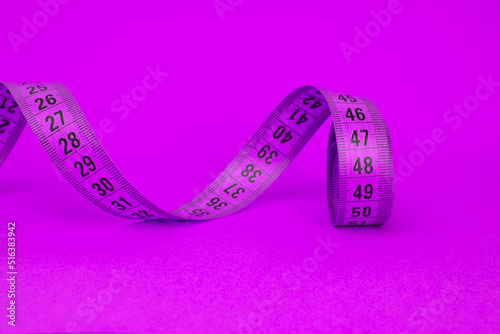 Spiral violet tape measure colorful background with copyspace