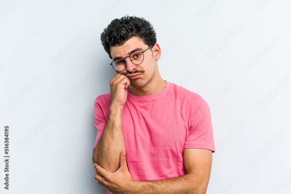Young caucasian man isolated on blue background tired of a repetitive task. Young caucasian man isolated on blue background tired of a repetitive task.