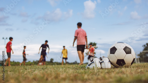 Action sport outdoors of kids having fun playing soccer football for exercise in community rural park. © nateejindakum