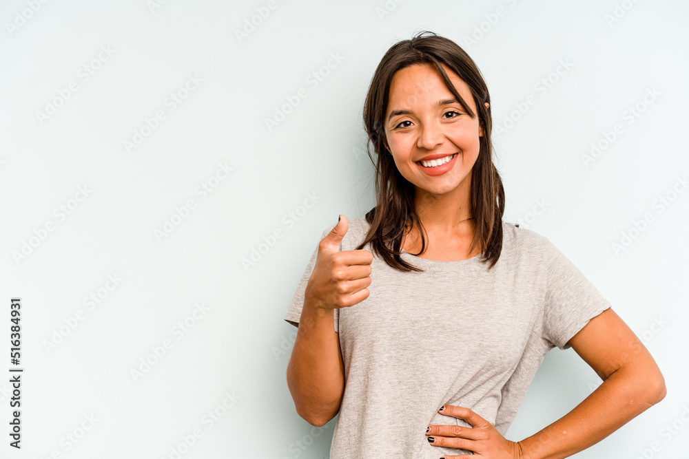 Young hispanic woman isolated on blue background smiling and raising thumb up Young hispanic woman isolated on blue background smiling and raising thumb up