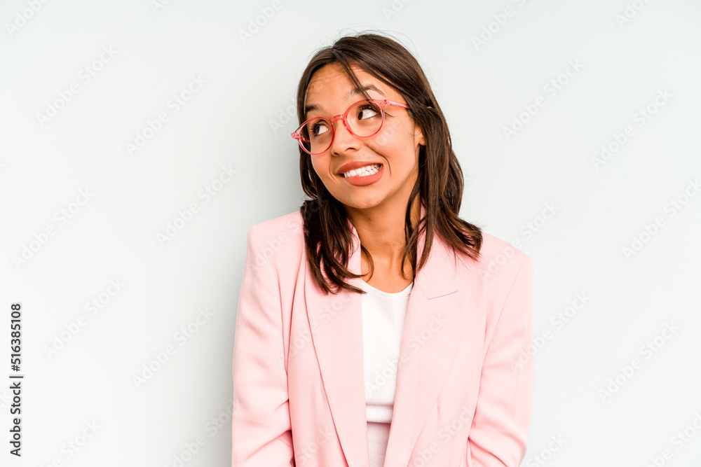 Obraz premium Young hispanic woman isolated on blue background feeling energetic and comfortable, rubbing hands confident.