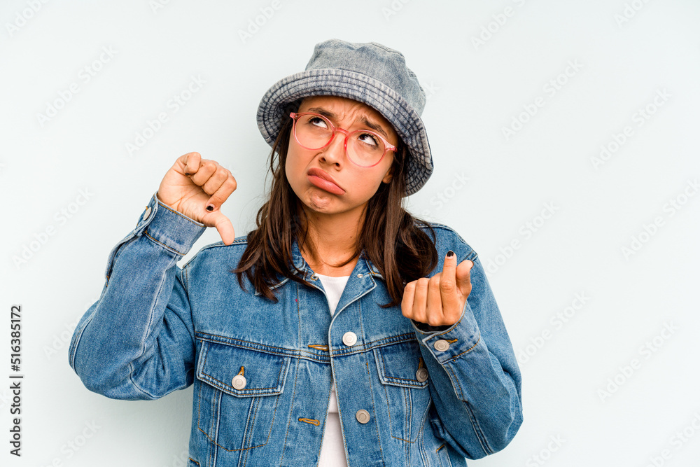 Young hispanic woman isolated on blue background looks aside smiling, cheerful and pleasant. Young hispanic woman isolated on blue background looks aside smiling, cheerful and pleasant.
