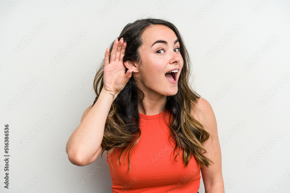Young caucasian woman isolated on white background trying to listening a gossip. Young caucasian woman isolated on white background trying to listening a gossip.