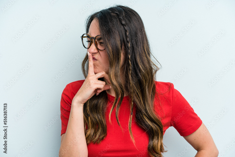 Young caucasian woman isolated on blue background keeping a secret or asking for silence. Young caucasian woman isolated on blue background keeping a secret or asking for silence.